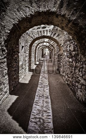 Long passage under stone arches from the old town of Villefranche de Conflent in the Conflent region of Catalonia, Pyrenees-Orientales department, France