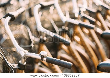Row Of City Parked Bicycles Bikes For Rent On Sidewalk. Bike Bicycle Parking In European City. Close Up Of Handlebar