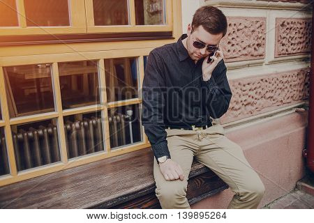 A guy in a nice town, walking, listening to music and taking pictures themselves on the phone