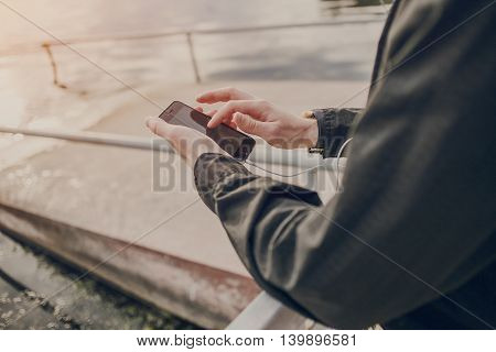 A guy in a nice town, walking, listening to music and taking pictures themselves on the phone