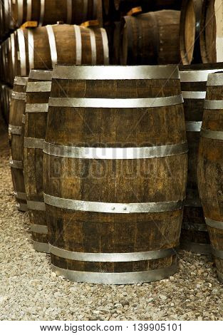 Wine barrels stacked in the old cellar of the winery.