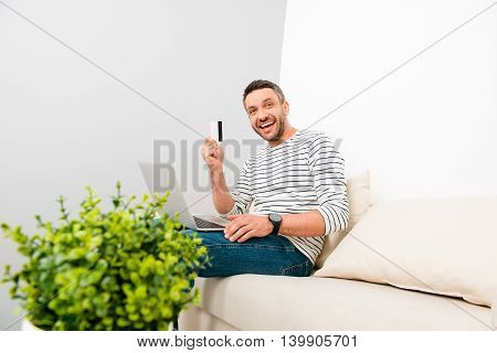 Happy Man Doing Internet Shopping And Holding Credit Card