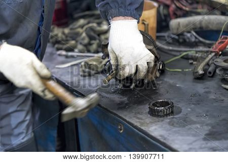 hand mechanic working with a hammer on a workbench