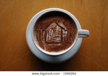 Xícara de café Latte com uma casa desenhada na espuma