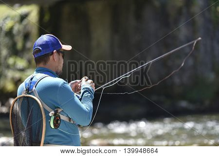 Fly-fisherman preparing fishing rod