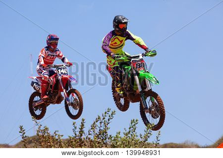 Wingate, Israel - July 23, 2016: Motocross rider and bike clearing a tabletop jump during the final heat of the race.
