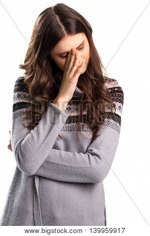 Woman covers face with hand. Young lady on blank background. Stricken with grief. Can't take it anymore.