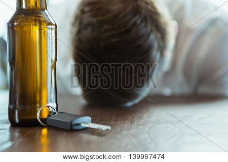 Depressed man with head down on a bar counter at restaurant