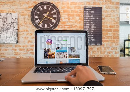 CHIANG MAI THAILAND - JUL 18 2016: A man using macbook laptop for instagram web application. Instagram is largest and most popular photograph social networking.