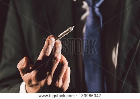 Business man's hand holding a joint in his hand