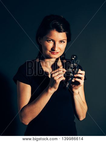 Smiling malefic woman with voodoo doll in her hands