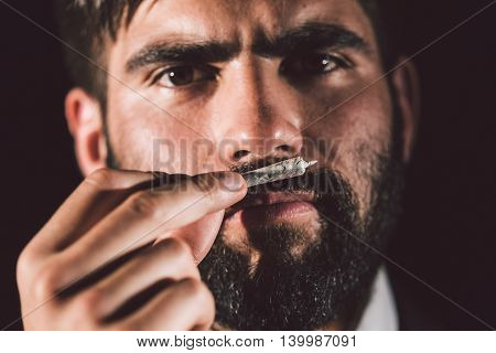 Man smelling a joint before smoking it
