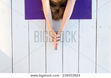 Woman Practicing Outdoors On Violet Yoga Mat. Overhead Close Up Of Female Hands In Mudra On White Wo