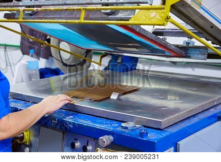Serigraphy print bags machine in printing factory with operator female hand