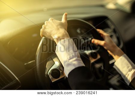 The Girl Holds Her Hands Behind The Wheel Of The Car.