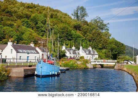 Blue sailboat moored near Bellanoch Swing Bridge at Crinan Canal connecting Crinan with Ardrishaig in Kintyre peninsula, Argyll and Bute, Scotland, UK