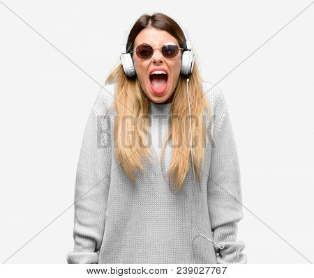 Young woman listen to music with headphone stressful, terrified in panic, shouting exasperated and frustrated. Unpleasant gesture. Annoying work drives me crazy