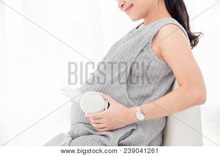 Pregnacy Woman Put Headset On Her Belly And Smiles