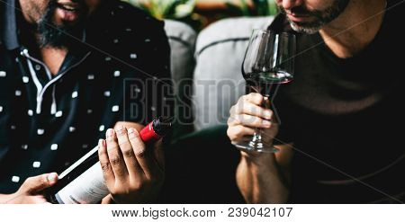 Man tasting red wine with friends