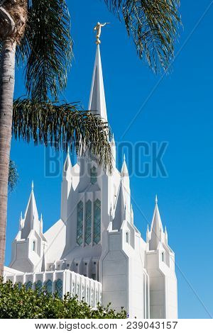 LA JOLLA, CALIFORNIA/USA - FEBRUARY 24, 2018:  A palm tree in front of the San Diego LDS (Mormon) temple, with a gilded statue of the angel Moroni blowing a horn atop the eastern spire.