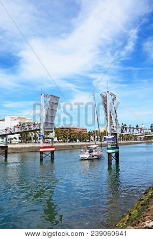 Lagos, Portugal - June 9, 2017 - Yacht Passing Through The Open Bascule Footbridge Along The River B