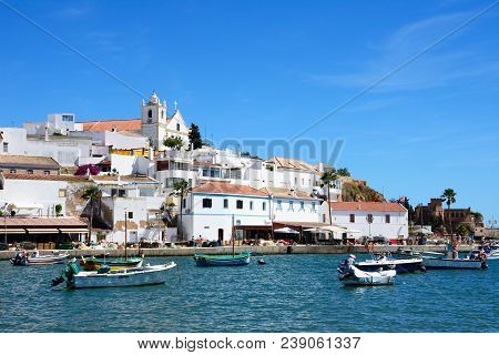 Ferragudo, Portugal - June 10, 2017 - View Of The White Town With Boats Moored In The Foreground, Fe