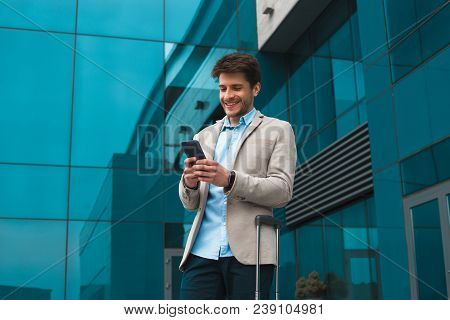 Achieving His Success! Smiling Handsome Young Man On Business Trip Text Business Messaging From His 