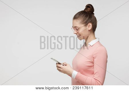 Side Portrait Of Young Beautiful European Female Pictured Isolated On Grey Background Wearing Bright