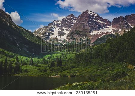 Majestic Maroon Bells Peaks And Maroon Lake On A Sunny Day And Blue Sky In Summer Near Aspen, Colora