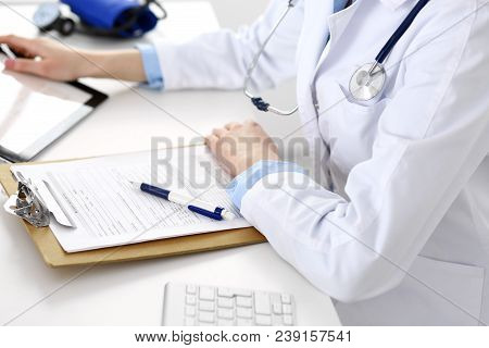 Woman Doctor Using Tablet Computer While Sitting At The Desk In Hospital Closeup. Cardiologist Check