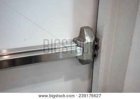 Closed Up Latch And Rusty Door Handle Of Emergency Exit. Push Bar And Rail For Panic Exit.