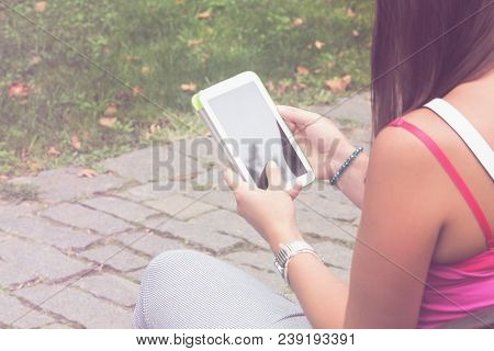Detail Of A Woman Using Tablet In The Park.