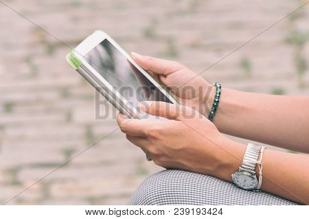 Detail Of A Woman Using Tablet In The Park.