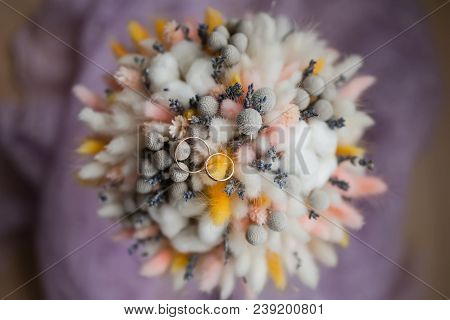 Wedding Rings On Bouquet Of Dry Flowers