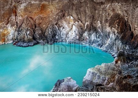 Fragment Of Blue Sulfur Toxic Lake In The Crater Of The Ijen Volcano. Poisonous Sulfur Smoke. Mounta