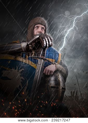 Lightning Strikes A Knight On Battlefield. Knight With Sword In Battlefield.