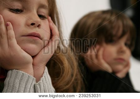 Girl And Boy With Hands On Face Sad.