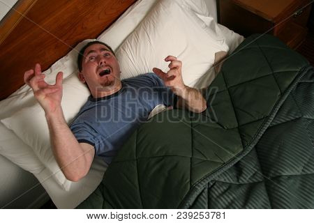 Man Waking From A Nightmare In Bed