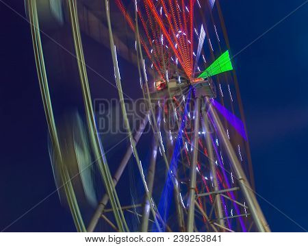 Carnival Ride Showing Spinning Ferris Wheel In Action- Long Exposure Shot.