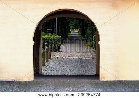 Gate Of A Historical Farmstead Behind A Narrow Road.