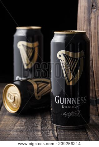 London, Uk - May 03, 2018: Aluminium Cans Of Guinness Draught Stout Beer Next To Wooden Barrel On Da