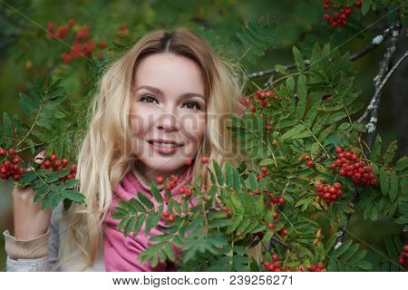 Portrait Of A Beautiful Young Woman In A Ash Berry Bush.