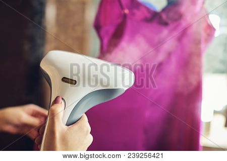 Woman Is Steaming A Dress. She Is Preparing For Occasion.