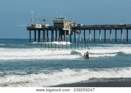 La Jolla, California/usa - April 28, 2018:  A Lone Female Surfer Heads Out To Sea Near The Scripps P