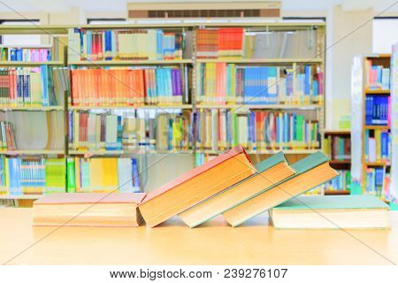 Old Book Red - Green. And Heap Treatise In School Library On Wooden Table.  Blurry Bookshelves Backg