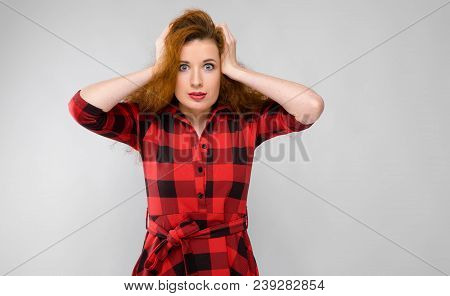 Charming Young Girl In A Checkered Cloth On A Gray Background