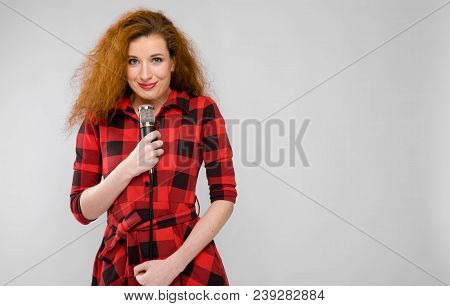 Charming Young Girl In A Checkered Cloth On A Gray Background