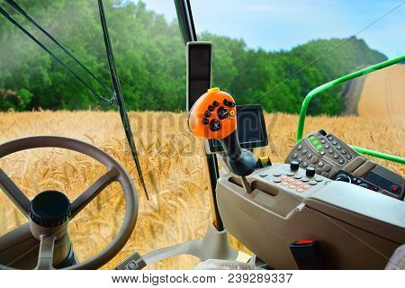 Combine Harvester Harvests Wheat. View From A Salon Of A Hi Tech Harvester.