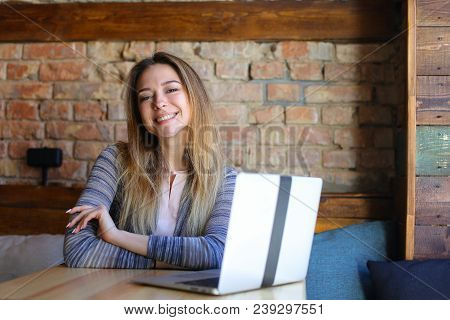 Cheeerful Female Person Using Internet By Laptop At Cafe. Concept Of Fast Internet And Free Hotspot.