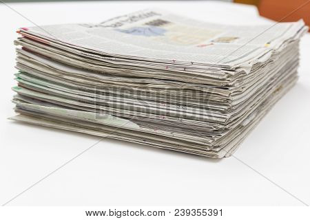 Closeup - Newspaper Stack On White Table In Work Office